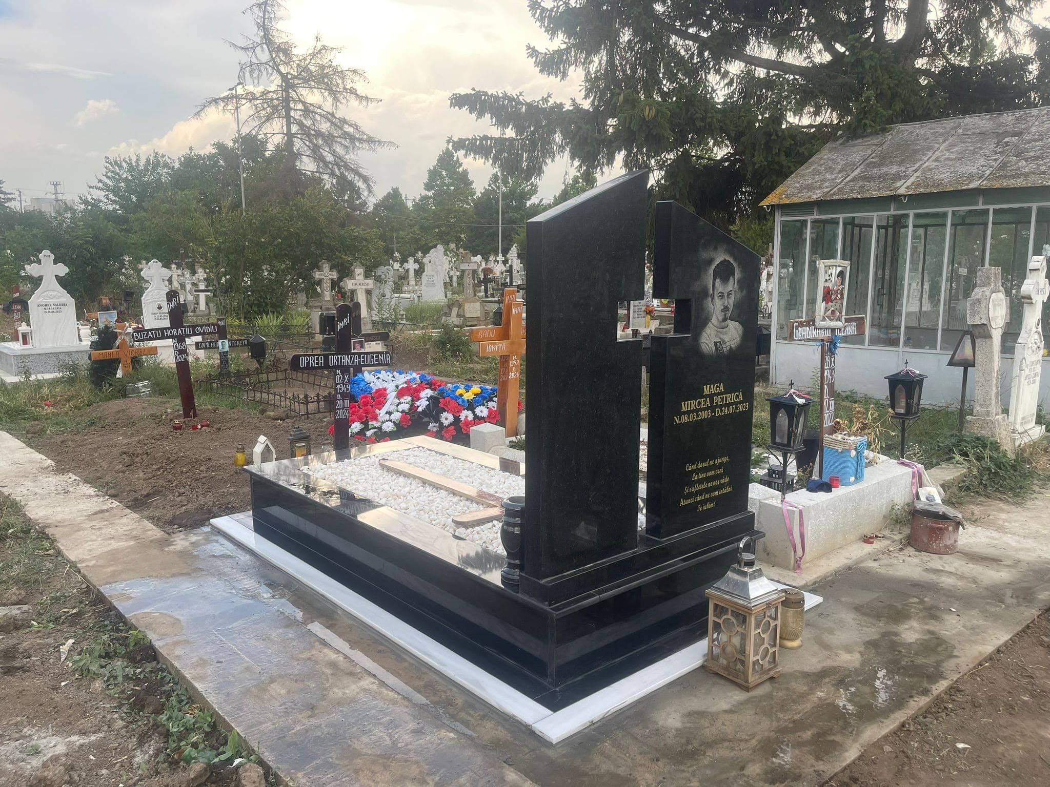 Monument modern din granit negru lustruit, cu portret gravat și pietriș alb