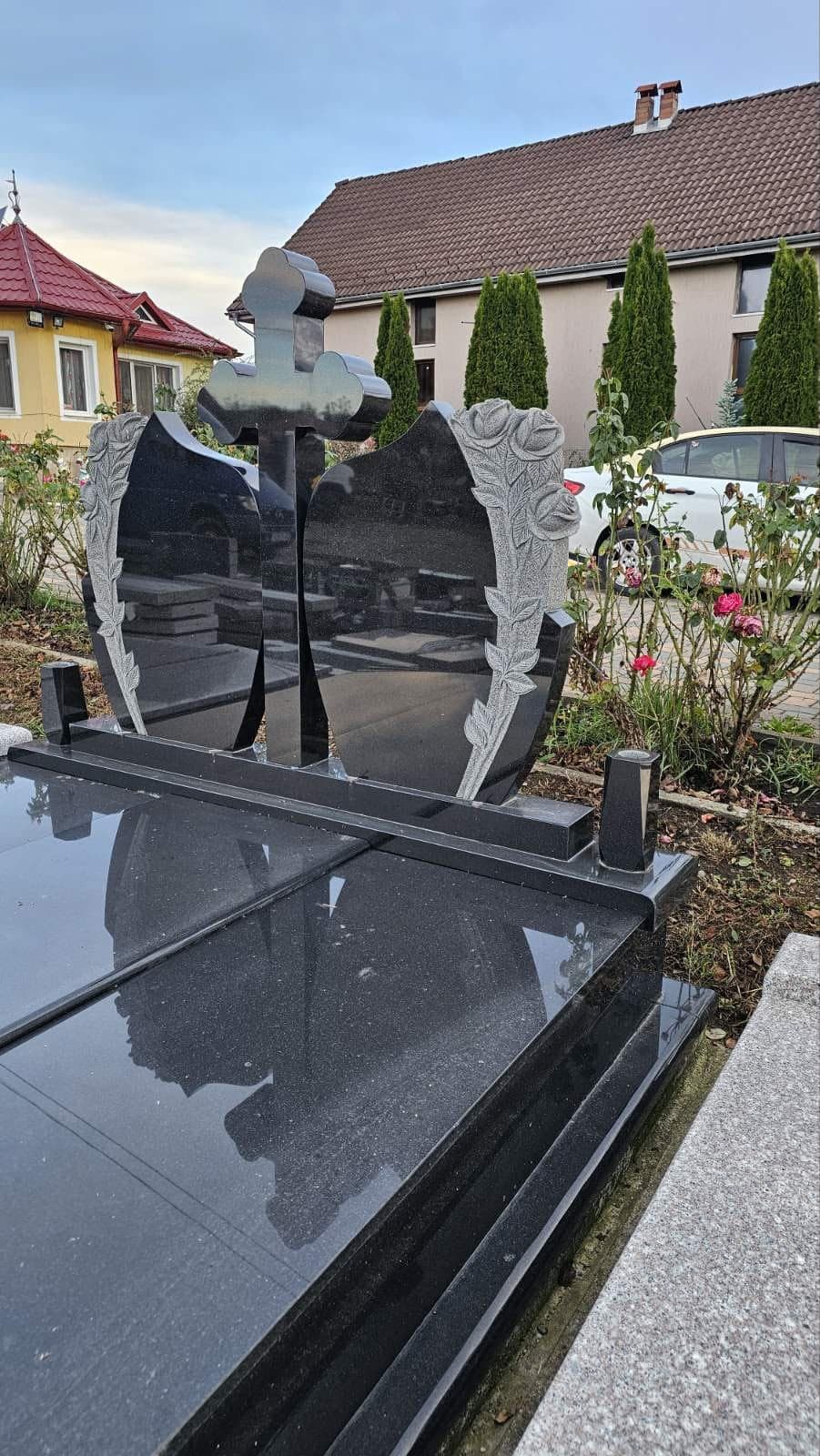 Monument funerar din granit negru cu cruce dublă și trandafiri gravați